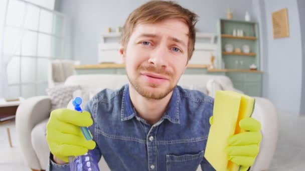 Portrait of crying upset houseman wearing yellow rubber gloves holding sponge and spray — Stock Video