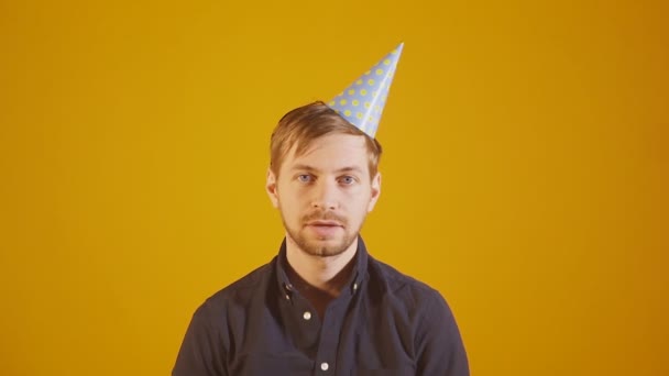 Unhappy man with cone hat looking at camera with bored dissatisfied expression — Stock Video