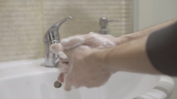 Mężczyzna myje ręce mydłem nad zlewem w łazience, walcząc z wirusami — Wideo stockowe