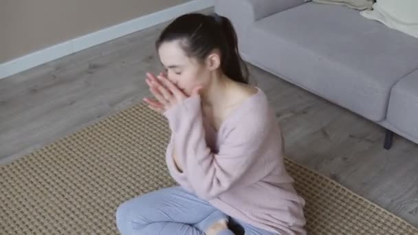Молодая грустная женщина страдает от депрессии, сидя на полу дома — стоковое видео
