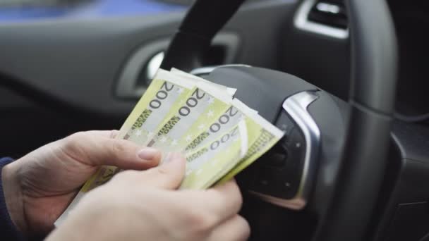 Homme comptant les billets en euros assis dans une voiture, Gros plan des mains masculines comptent l'argent comptant. Notion de rémunération ou de pots-de-vin, d'assurance ou de crédit, d'investissement — Video