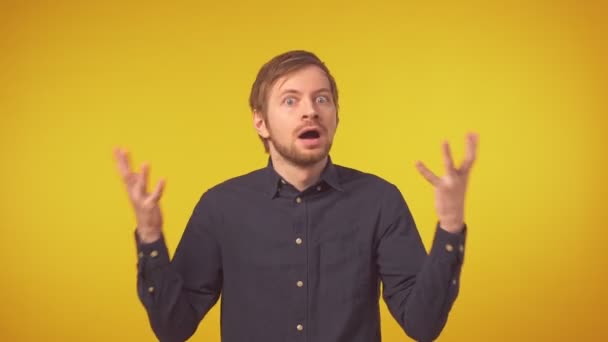 Portrait of young man in shirt with sad expression isolated on yellow background — Stock Video