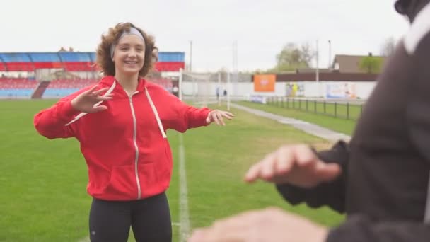 Ung tonåring flicka löpare uppvärmning utomhus på stadion innan träning — Stockvideo