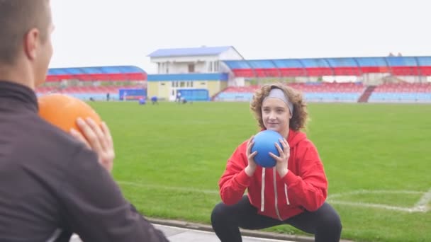 Jong sportief meisje doen oefening buiten in het stadion — Stockvideo