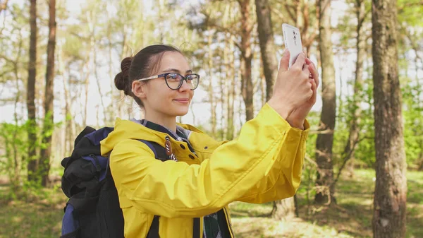 Wanita muda hiking mengambil foto dengan ponsel pintar di hutan — Stok Foto