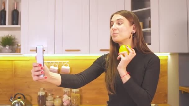 Porträtt av positiv vänlig flicka med videosamtal på kök visar färsk peppar — Stockvideo