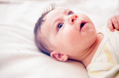 Yeni doğmuş yakışıklı bebek. Yatakta yakın plan yüzü..