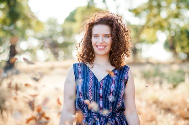 Genç, güzel mavi gözler ve kıvırcık saçlı kız doğada