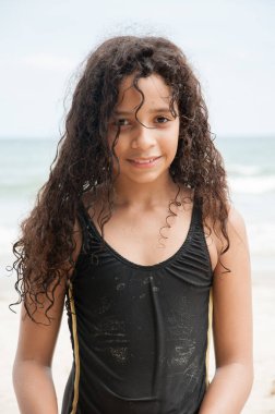 Güzel Latin Amerikalı kıvırcık saçlı kız Lagoinha sahilinde gülümsüyor, Ubatuba.