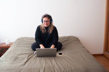 Mutlu kadın yatak odasındaki bilgisayarı kullanıyor..