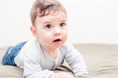 Yatakta sürünen tatlı bir erkek bebek. Huzurlu bir gezisi var. Harika kopyalama alanı.