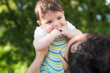 Babasının kollarında doğada tatlı bir erkek bebeğin önü..
