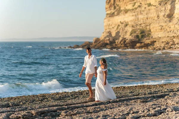 新郎新婦が美しいビーチで手をつないで歩いています 素晴らしいコピースペース — ストック写真