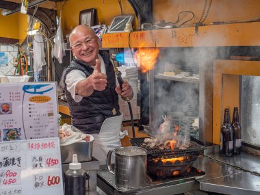 Toyo-san, Osaka 'daki Izakaya Toyo' nun sahibi. 17 Ocak 2020 'de Osaka, Japonya' da yemek pişirmek için alev püskürtücü meşalesiyle sadece çıplak elini kullanır.