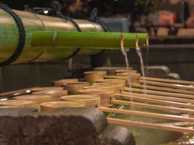 Geleneksel el yıkama göleti bambu su borusu ve kepçelerle Japon tapınağı ya da türbesine girmeden önce el yıkamak için, Kyoto, Japonya, Ocak 2020
