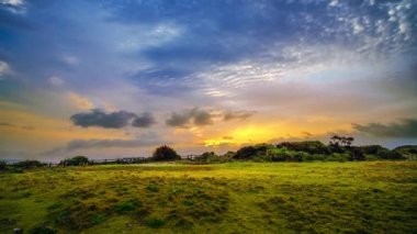 Cape Manzamo bölgesinde gündoğumunun hızlandırılmış görüntüsü, altından maviye gökyüzü ve arka plan olarak güzel bulut geçişi. Okinawa, Japonya, Nisan 2018.