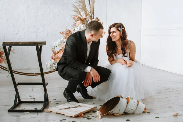 Drie lagen bruidstaart vallen van de tafel. Emoties van de bruid en bruidegom als de taart valt — Stockfoto