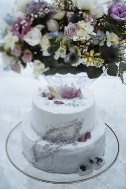 Üzerinde düğün pastası olan cam bir buket.