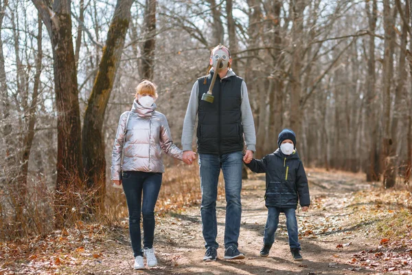 A small family in sanitary masks on a walk in the Park. People walk in the conditions of the quarantine