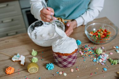 Ev mutfağında bir aşçı Paskalya pastasına krema koyar.