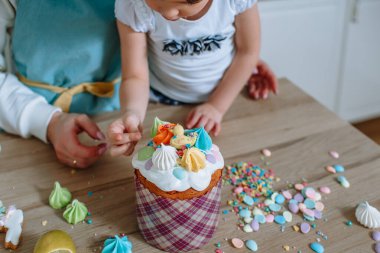 Aşçı ve kızı, Paskalya pastasının üzerine tatlı figürler sererler.