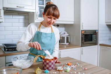 Ev mutfağında bir aşçı Paskalya pastasına krema koyar.