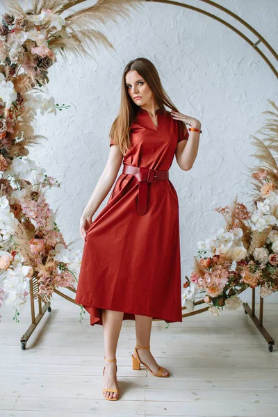 Model Mädchen Einem Roten Kleid Auf Dem Hintergrund Eines Blumenbogens — Stockfoto