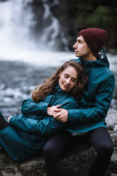 Casal Amantes Capas Chuva Verdes Sentados Uma Rocha Contra Pano — Fotografia de Stock