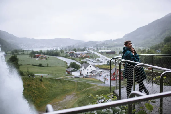 Los Amantes Los Impermeables Verdes Abrazan Contexto Una Cascada Noruega — Foto de Stock