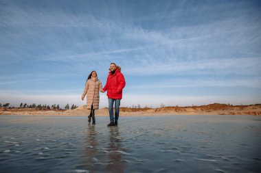Ceketli aşıklar kum çukurlarında yürür.
