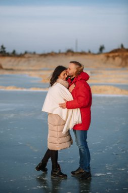 Ceketli aşıklar kum çukurlarında yürür.