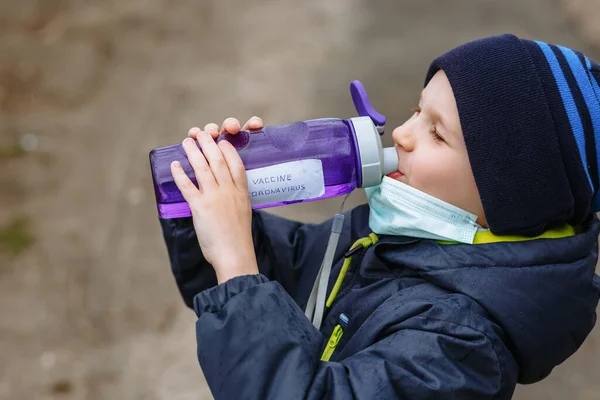 Niño Con Una Máscara Médica Bebiendo Agua Biberón Que Dice — Foto de Stock
