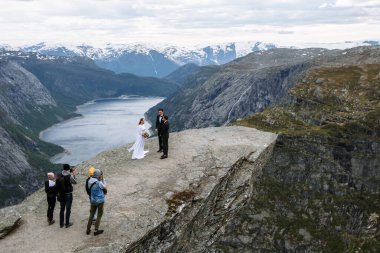 Fotoğrafçılar ve kameramanlar Norveç 'te Troll' un Dili adlı bir kaya parçasında düğün töreni çekiyorlar.