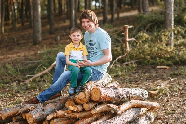 Sohn Und Vater Sitzen Einem Kiefernwald Auf Einem Haufen Brennholz — Stockfoto