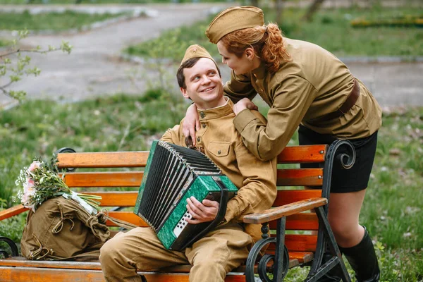 Ένας Στρατιώτης Κάθεται Ένα Παγκάκι Και Παίζει Ακορντεόν Πίσω Είναι — Φωτογραφία Αρχείου