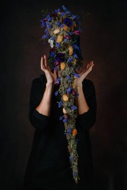 Erkek sanat modeli, uzun saçlı, dalları ve çiçekleri olan bir büyücü şeklinde. Dekoru bir adamda hissettim.