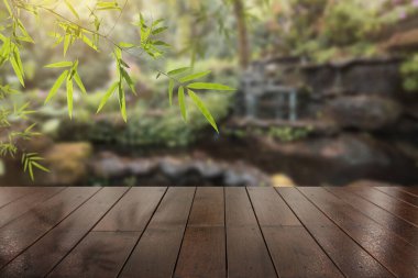 Güzel şelale arkaplanı ve bedava kopya alanı olan ahşap teras.