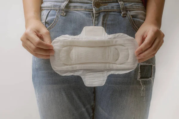 Young woman holding menstrual pad ,Women Period Product. Closeup asian female holding Sanitary Napkin, In Hand. Woman Holding Clean Period Pad. Feminine Intimate Hygiene. High Resolution