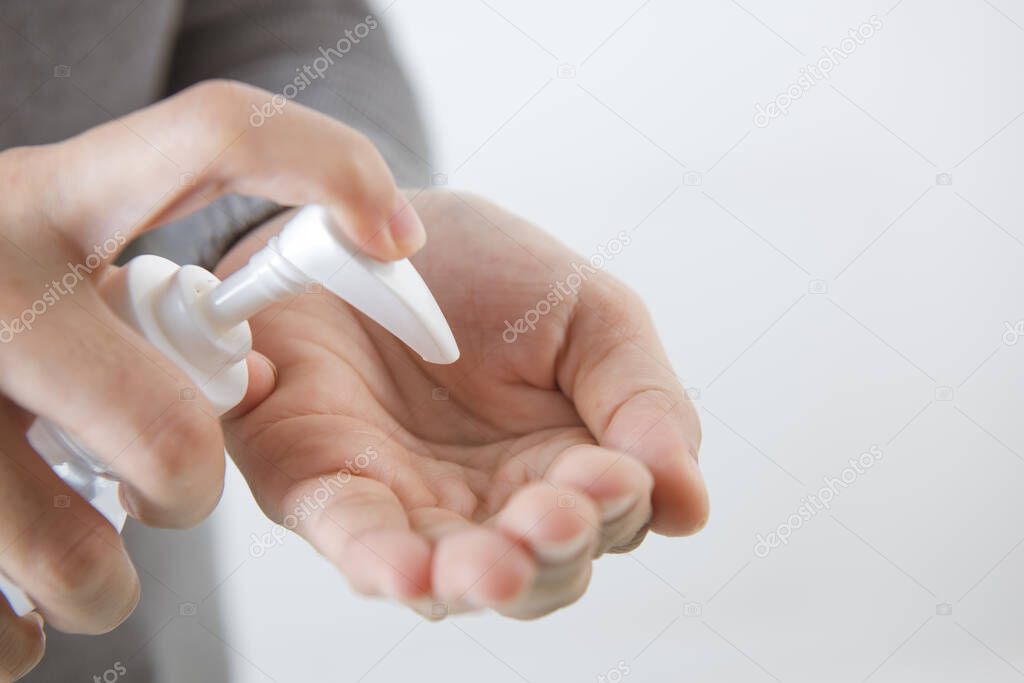 Female hands using washing hand with Alcohol Sanitizer isolate on a white background. Promoting people use face mask to protect themselves from virus infection in Corona virus crisis 2020