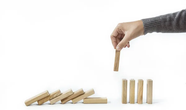 Social Distancing and quarantine impact on pandemic spread of a virus in population. Concept hand stopping falling wooden dominoes for containing corona virus or any virus or pandemic outbreak.