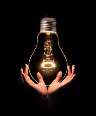 Eldeki ampul siyah arkaplanda izole edildi. Enerji ya da fikir kavramı
