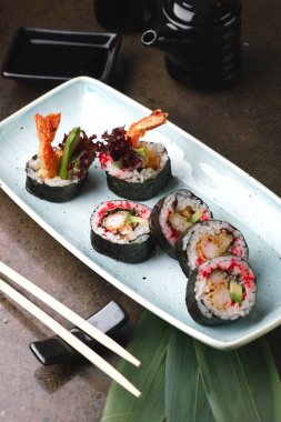 Suşi Roll balık ile güzel bir mavi tabak içinde. 