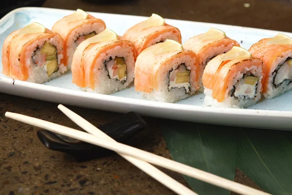 Sushi-Rolle mit Fisch in einem schönen blauen Teller. — Stockfoto