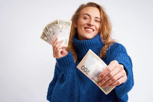 Радостная женщина делится деньгами, держа их в руках на гр. — стоковое фото