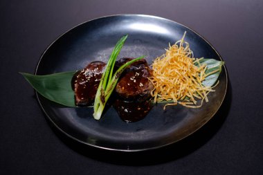 Siyah tabakta otlu soya soslu köfteler. Japon yemeği..