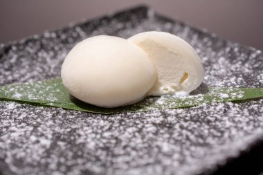 Kaynamış yumurta siyah bir tabakta ikiye bölünmüş.