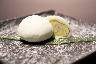 Kaynamış yumurta siyah bir tabakta ikiye bölünmüş.