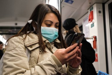 Milan, İtalya, Lombardiya -25 Şubat 2020: Yüzü maskeli insanlar kendilerini Milan sokaklarındaki koronavirüs salgınından korumak için