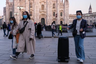 Milan, Italy, Lombardy -25 February 2020: People in face masks to protect themselves from the coronavirus epidemic on the streets of Milan clipart