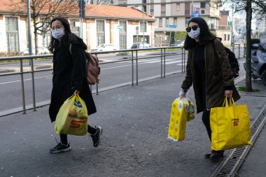 Milan, İtalya, Lombardiya - 25 Şubat 2020: maskeli insanlar kendilerini Milano sokaklarındaki korona virüsü salgınından korumak için